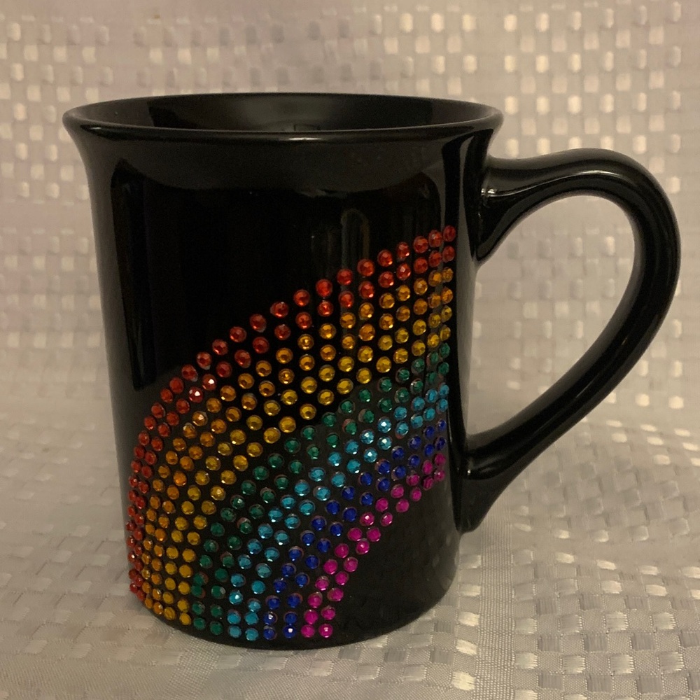 Black coffee mug with rainbow rhinestone design.